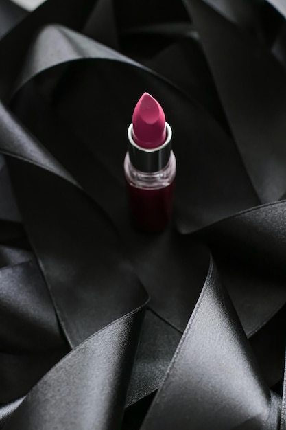 Różowa szminka na czarnym jedwabnym tle luksusowy makijaż i kosmetyk kosmetyczny