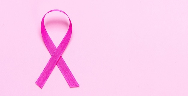 Zdjęcie różowa wstążka na pastelowym różowym tle świadomość raka piersi