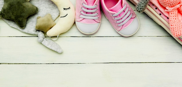 Różowe buty dla dziewczynki, noworodka i miękkie zabawki. Koncepcja macierzyństwa, edukacji lub ciąży z miejsca kopiowania. Baner