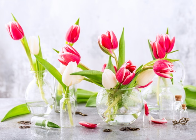 Różowe i białe tulipany w szklanych wazonach