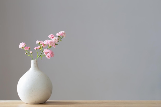 różowe róże w ceramicznym wazonie na drewnianym stole