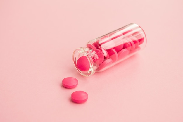 Różowe Tabletki I Szklana Butelka Na świetle. Zdrowie I Medycyna Kobiet