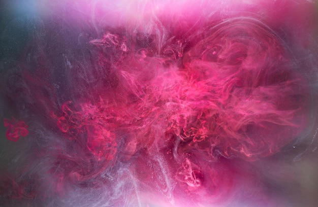 Różowe tło atramentu dymnego, kolorowa mgła, abstrakcyjny wirujący dotyk oceanu, pigment do farby akrylowej pod wodą