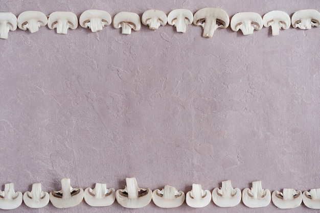 Zdjęcie różowe tło z teksturą i ramka z plastrów grzybów