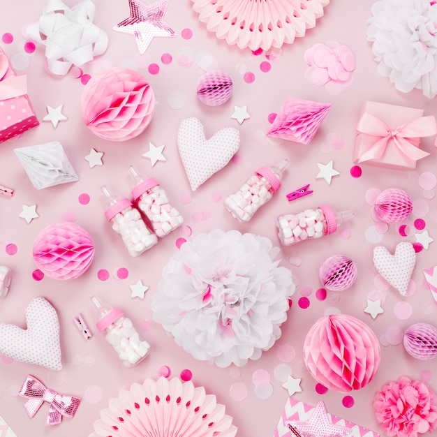 Różowo-białe ozdoby papierowe, pom-pom, cukierki, serduszka, prezenty, konfetti na przyjęcie dla dzieci. Koncepcja urodziny. Płaski układanie, widok z góry