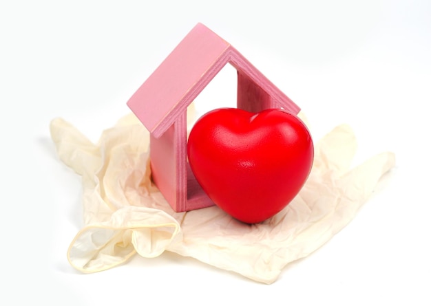 Różowy drewniany dom czerwone serca z gumowymi rękawiczkami na białym tle Gniazdo miłości