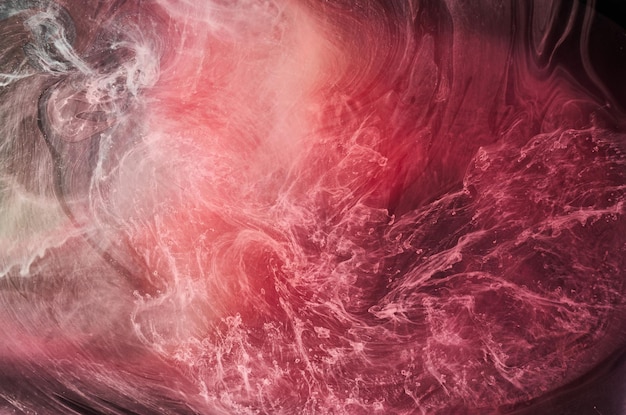 Różowy dym na czarnym tle, kolorowa mgła, abstrakcyjny wirujący dotyk oceanu, pigment do farby akrylowej pod wodą