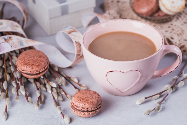 Różowy kubek kawy ze słodkimi pastelowymi francuskimi makaronikami