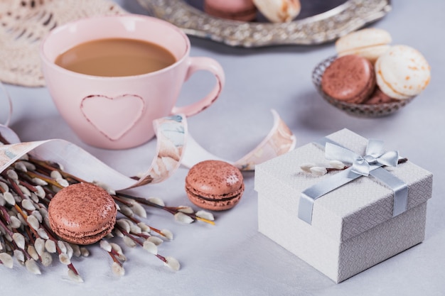 Różowy kubek kawy ze słodkimi pastelowymi francuskimi makaronikami