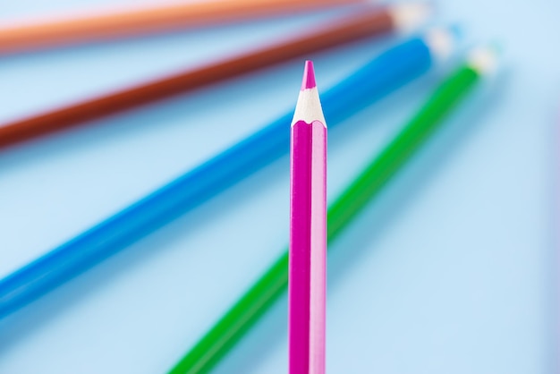 Różowy ołówek na tle kolorowych ołówków