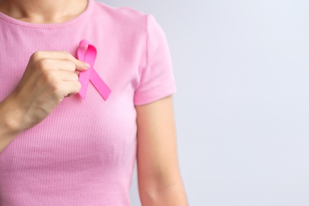 Zdjęcie różowy październikowy miesiąc świadomości raka piersi kobieta ręka trzyma różową wstążkę i nosi koszulę dla wsparcia życia i choroby ludzi miesiąc osób, które przeżyły raka, koncepcja dnia matki i świata na raka
