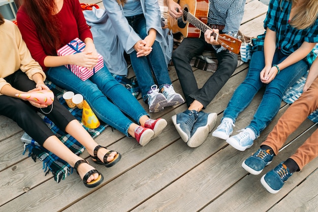 Rozrywka Młodzieży. Beztroscy młodzi ludzie śpiewają piosenki, grają na gitarze i odpoczywają. Alternatywna subkultura, nieszablonowe poglądy na życie