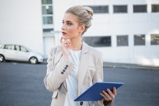 Rozważny elegancki bizneswoman używa cyfrową pastylkę