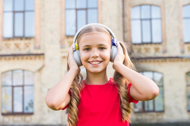 Rozwiń możliwości Zainspirowana muzyką Dziewczyna słuchająca muzyki nowoczesny gadżet Urocze dziecko z bezprzewodowym zestawem słuchawkowym Słuchawki stereo Urocze dziecko korzystające z nowoczesnej technologii Nowoczesne dziecko Doskonały dźwięk