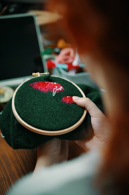 Ruda dziewczyna haft kapelusz grzyb w obręczy na zielonym materiale koncepcja robótki hobby rozrywka c...