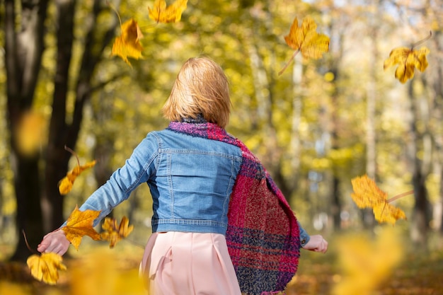 Rudowłosa dziewczyna idzie przez jesienny park