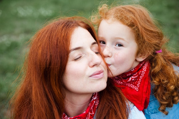 Rudowłosa mama i córka bawią się na łonie natury