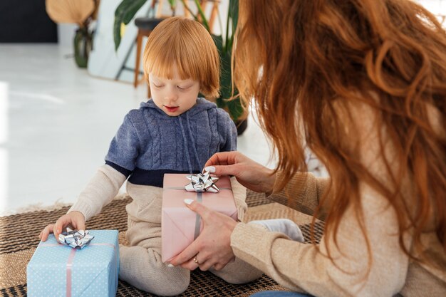 Zdjęcie rudowłosa mama wesoło przygotowuje prezenty świąteczne ze swoim synem