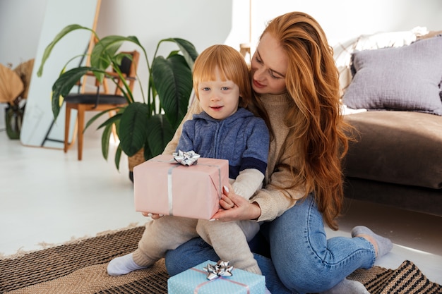 Rudowłosa mama wesoło przygotowuje prezenty świąteczne ze swoim synem