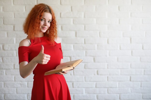 Rudowłosa studentka na tle ceglanego muru