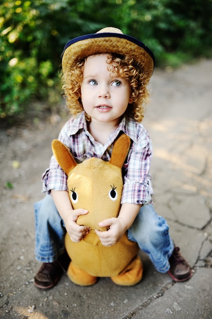 Zdjęcie rudzielec mała dziewczynka jedzie zabawkarskiego konia.