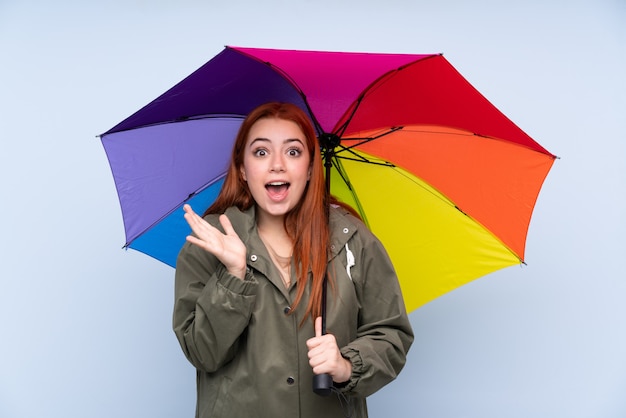 Rudzielec nastolatka kobieta trzyma parasol z niespodzianka wyrazem twarzy