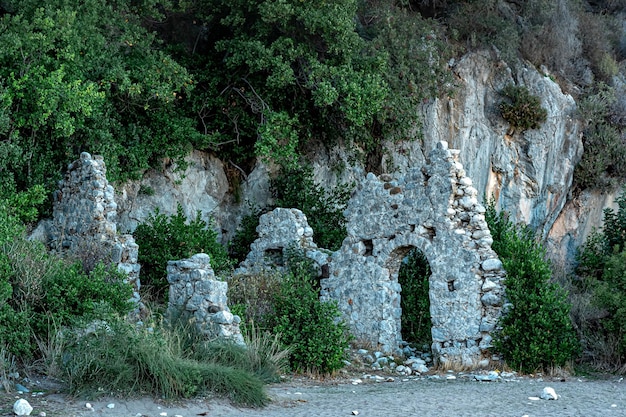 Ruiny starożytnego budynku na tle gór w antycznym mieście Olympos, Turcja