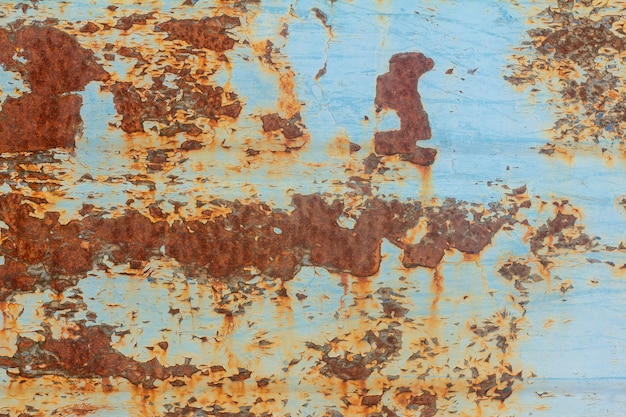 Rust.Old niebieski malowane ściany z plamami rdzy. Teksturowane zardzewiałe tło metalowe. Plamy rdzy przez spękaną niebieską farbę.