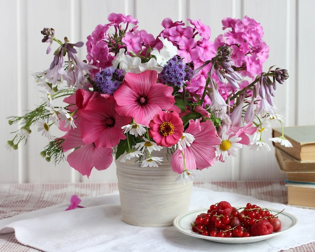 Rustykalna Martwa Natura Z Kwiatami I Jagodami Bukiet Różowych Kwiatów Floks Lavater Rumianek Hosta Ageratum I Malina Czerwona Porzeczka Na Talerzu