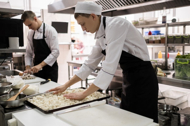 Rutynowa praca polegająca na przygotowywaniu składników na pyszne dania restauracyjne. Kucharze w pracy w kuchni