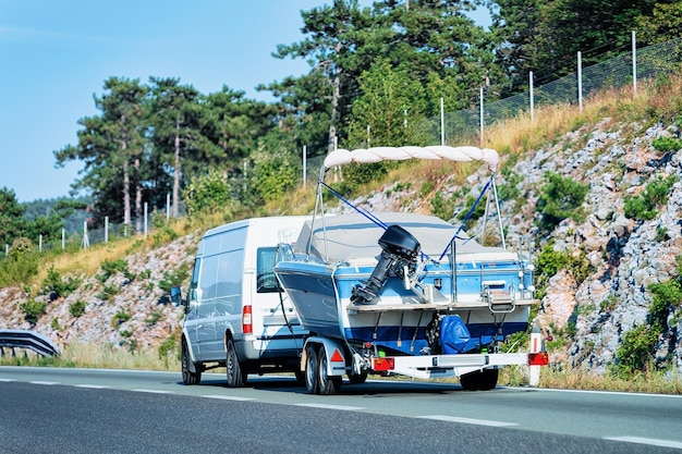 Zdjęcie rv camper car z motorówką w road. przyczepa kempingowa i kamper w podróży po słowenii.