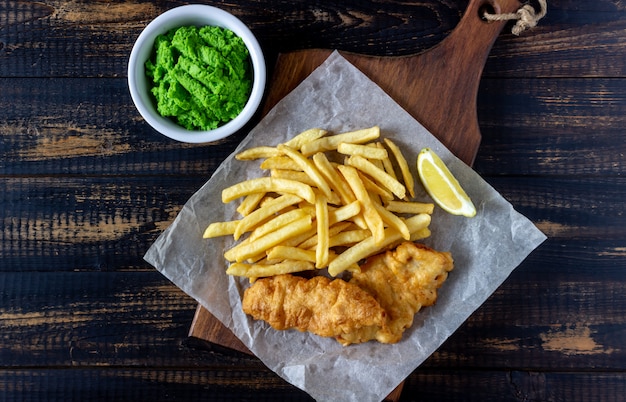 Ryba i układy scaleni na drewnianym tle. Brytyjskie fast foody. Przepisy Przekąska do piwa. Kuchnia angielska.