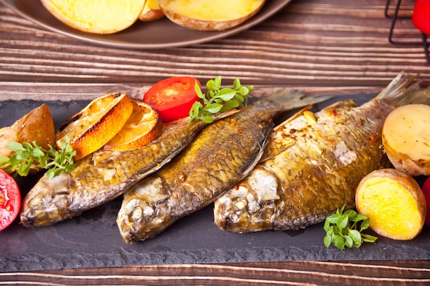 Ryba z grilla na talerzu z cytryną i warzywami