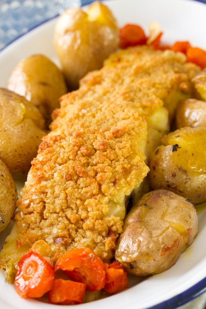 Ryba z ziemniakiem i marchewką na naczyniu