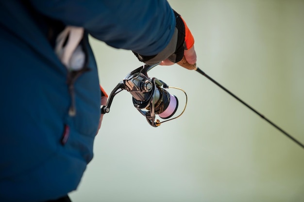 Rybak kaukaski trzyma w rękach wędkę spinningową, zbliżenie. Wędkarstwo sportowe. spinning rod