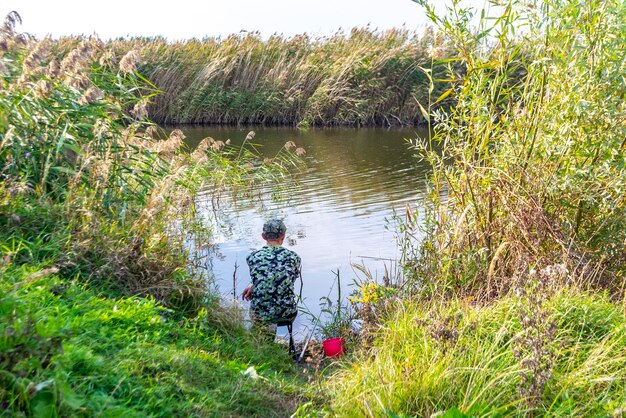 Zdjęcie rybak nad jeziorem w słoneczny letni dzień