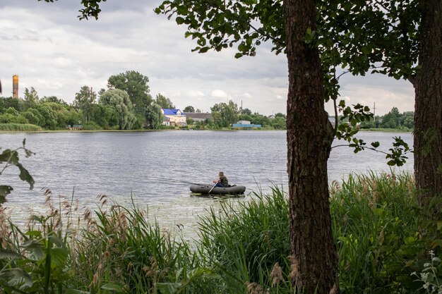 Rybak w łodzi na środku rzeki