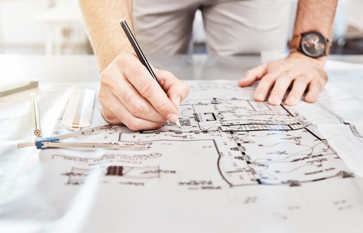 Zdjęcie rysowanie konstrukcji na planie planowania architektury na papierze i pisanie notatek na dokumentach budowlanych na stole w biurze pracy projektant architekt i budowniczy ze strategią renowacji