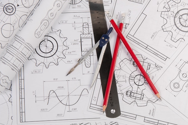 Zdjęcie rysunki łańcuchów przemysłowych, kompas techniczny, linijka i ołówki