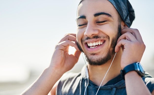 Rywalizacja wprowadza go do strefy fitness Ujęcie wysportowanego młodego mężczyzny słuchającego muzyki podczas ćwiczeń na świeżym powietrzu