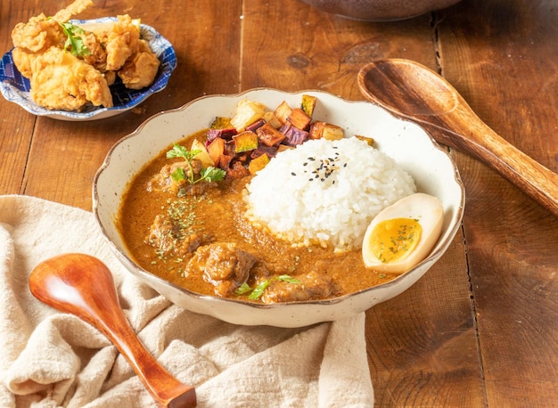 Ryż Curry Signature Beef Spice w misce na drewnianym stole z widokiem na tajskie jedzenie