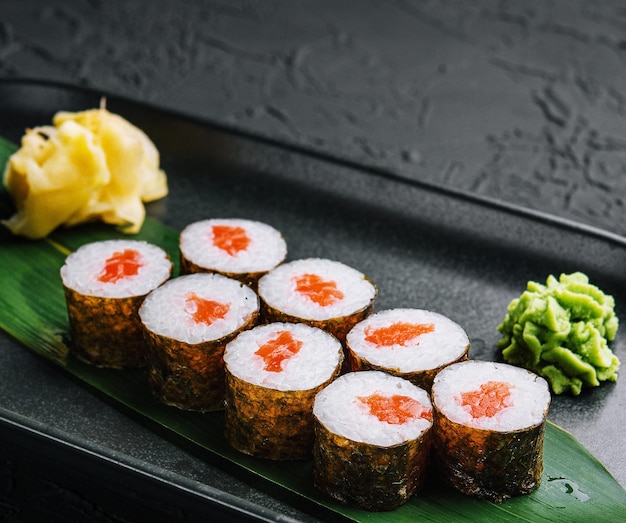 Zdjęcie rząd świeżych rolek sushi maki na czarnym talerzu