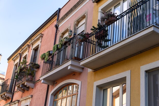 Rzęd kolorowych budynków z balkonami i roślinami w doniczkach