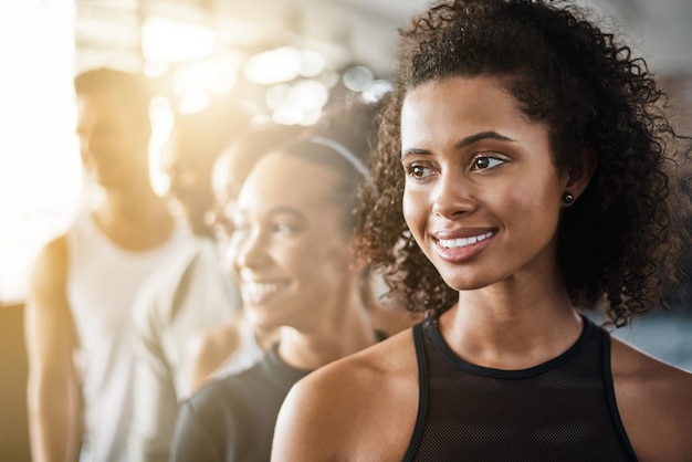 Rzędowy uśmiech i ludzie na siłowni na trening fitness i myślenie o ćwiczeniach Szczęśliwy wygląd i grupa przyjaciół w klubie na trening cardio i pomysły na zajęcia odnowy biologicznej razem jako zespół