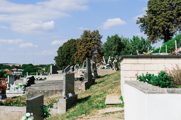 Rzędy starych opuszczonych grobów na cmentarzu katolickim. Rozklekotane nagrobki.