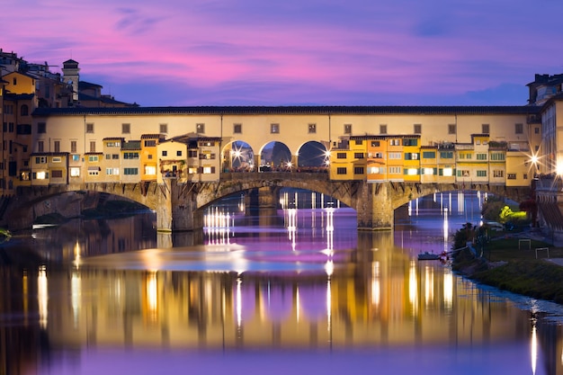 Rzeka Arno i słynny most Ponte Vecchio o zachodzie słońca we Florencji, Toskania, Włochy