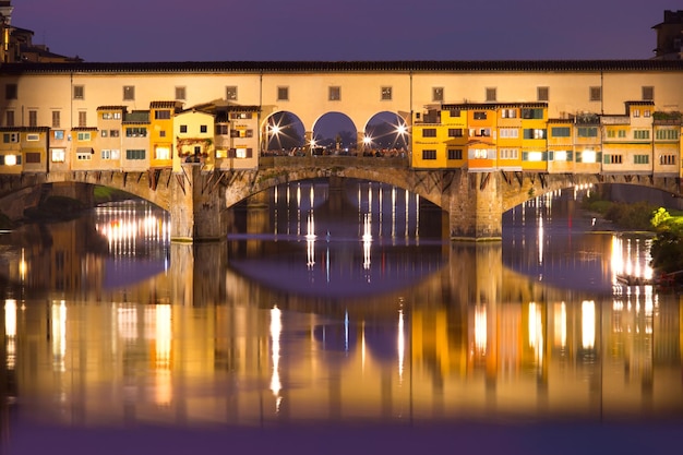 Rzeka Arno i słynny most Ponte Vecchio w nocy we Florencji, Toskania, Włochy