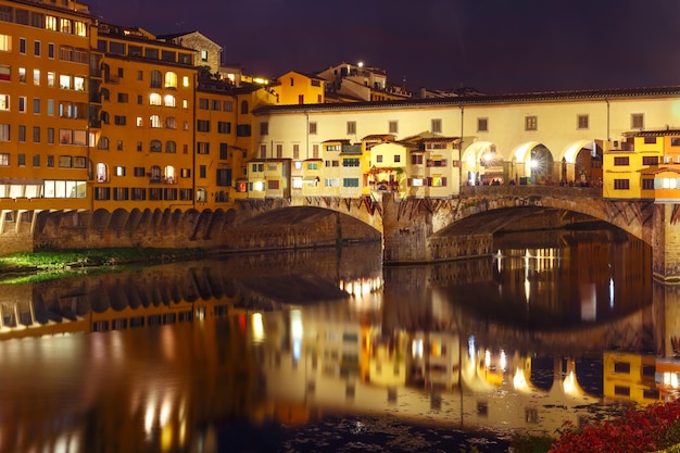 Rzeka Arno i słynny most Ponte Vecchio w nocy we Florencji, Toskania, Włochy