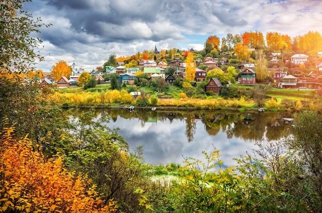 Rzeka Shokhonka w Plyos w jesiennej dekoracji i wiele małych domków w mieście