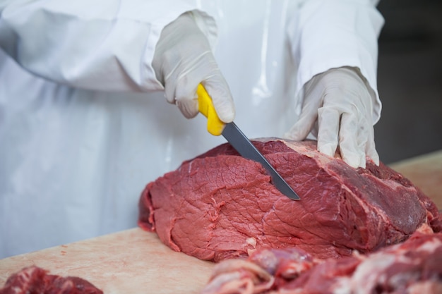 Zdjęcie rzeźnik rozbioru mięsa w fabryce mięsa